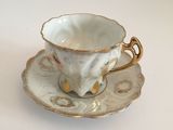 a cup and saucer on a saucer on a white table