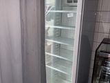 an empty refrigerator in the corner of a kitchen