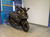 une moto noire garée devant un panneau bleu et blanc