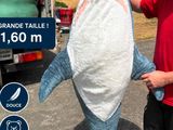 un homme debout à côté d'un grand requin empaillé