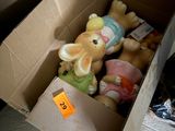 une boîte remplie de peluches posée par terre