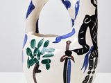 a white vase with blue and green designs on it