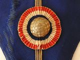 a close up of a blue ribbon with a red, white and blue ribbon around it