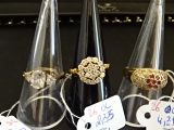 trois cônes transparents munis d'anneaux et d'étiquettes de prix