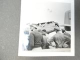 une photo en noir et blanc montrant un groupe d'hommes travaillant sur un avion
