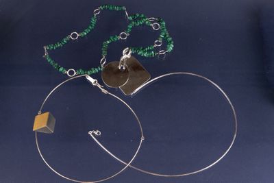 une paire de boucles d'oreilles créoles ornées d'une perle verte