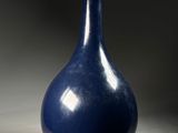 a blue vase that is sitting on a table