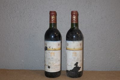 two bottles of wine sitting on a table next to each other