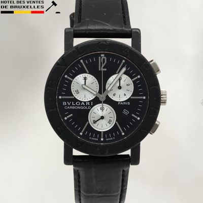 La montre est noire, avec un cadran blanc et un bracelet en cuir noir.