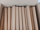 cardboard box containing a large amount of rolls of tan colored paper