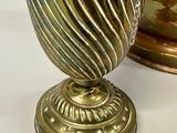 a gold vase sitting next to a silver vase
