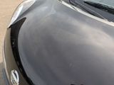 a close up of the hood of a car in a parking lot