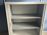 a metal cabinet with shelves in the corner of the room