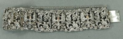un gros plan d'un bracelet en argent posé sur une surface grise