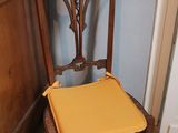 a wooden chair with a yellow seat next to a door