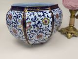 a blue and white vase sitting next to a pink vase