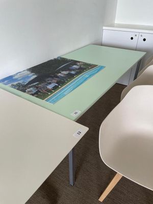 a glass table with a picture on it in the corner of a room