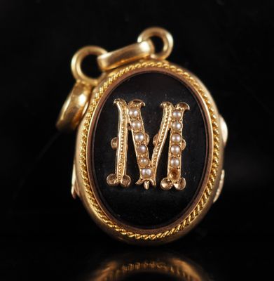 a close up of a black and gold locke with a letter m on it