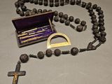 rosary with a cross and a wooden box on a table
