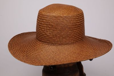 une photo d'un chapeau de paille marron posé sur une tête de mannequin