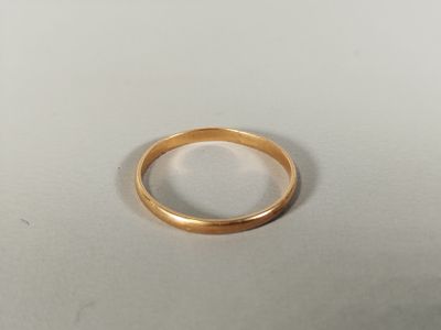 gros plan d'une bague en or sur une surface blanche