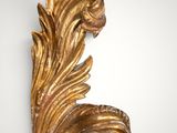 an ornate gold leaf decoration on a white wall