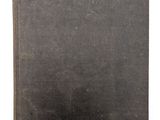 un vieux livre à la couverture noire posé sur une surface blanche