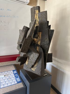 une sculpture posée sur une table devant un tableau blanc