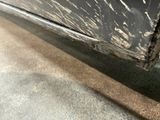 a close up of a black car with white paint on it