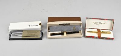 trois stylos dans une boîte et un stylo dans une boîte