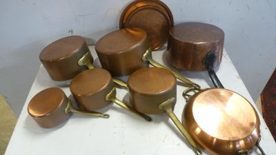 de nombreuses casseroles et poêles posées sur une table