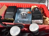 a red case with a camera, flash and other items in it