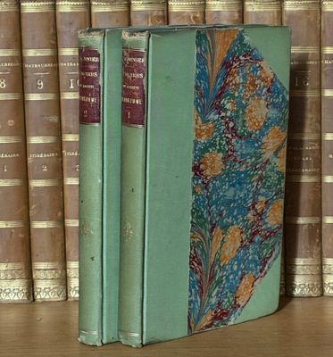 un livre posé sur une étagère, devant une pile de livres
