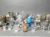 many different types of glass vases and glasses on the table