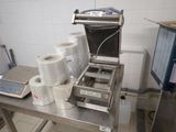 une machine posée sur une table, avec des rouleaux de papier toilette à côté