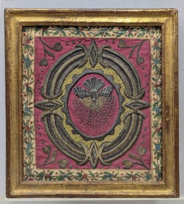painting of a flower in a gold frame on a pink background