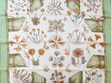 a close up of a green and white square with flowers on it