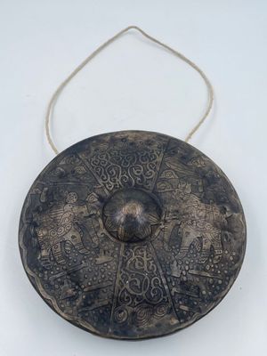 an old metal object on a white surface with a rope