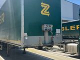 a green semi truck that is parked in front of a building