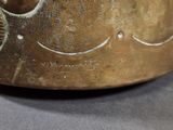 a metal bowl with a design on it on a table