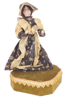 figurine représentant une femme en robe et chapeau, posée sur un coussin