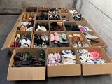 plusieurs paires de chaussures dans une boîte en carton posée sur le sol