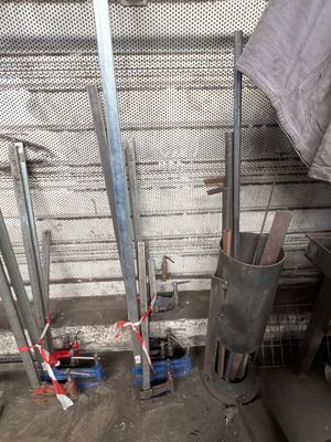 a pile of metal pipes that are next to a wall