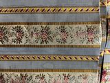 a close up of a blue and yellow blanket with a floral design on it