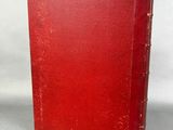 a red book sitting on top of a table next to a white wall
