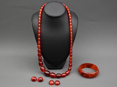 Un collier, un bracelet et une bague sont exposés sur un mannequin