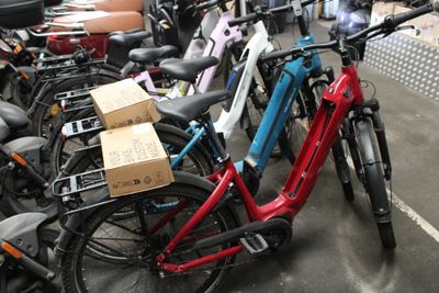 many bikes parked in a parking lot with boxes on them