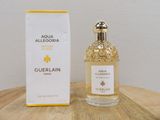an image of a bottle of perfume sitting on top of a wooden table