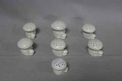 a lot of small white ceramic mushrooms on the table