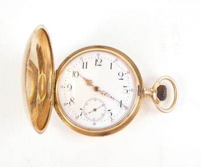 a gold pocket watch sitting on a white surface